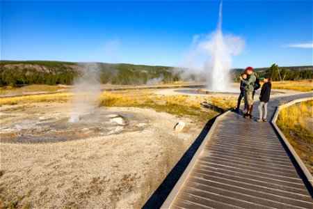 Family watching Tardy and Sawmill geysers erupt from boardwalk photo