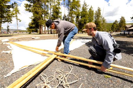 Yellowstone Tribal Heritage Center opening day 2023: artist Mike Redman tying poles together