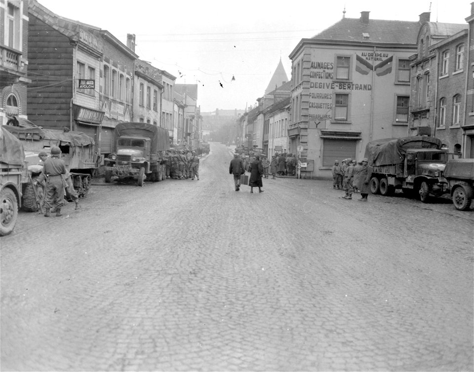 SC 329952 - Troops of 10th Armored Division preparing for attack on German spearhead headed toward Bastogne, Belgium, await order to move out. Note refugees in foreground. 19 December, 1944. photo