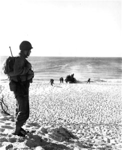 SC 184762 - Soldier of 32nd Div. stands guard while men run off LCIs during amphibian training of 32nd Div.
