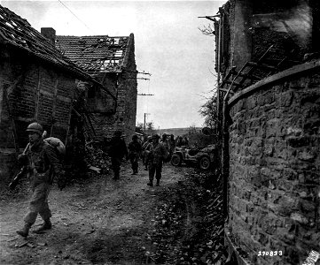 SC 270833 - Members of the 9th Infantry Division, U.S. First Army, move through the ruins in the town of Thum, on the way to Ginnick, Germany. 1 March, 1945.