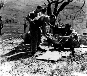 SC 374849 - Members of a 3 inch mortar platoon of the Jewish Inf. Brigade have fried matzo in between German shelling. Pideura area, Italy. 30 March, 1945.