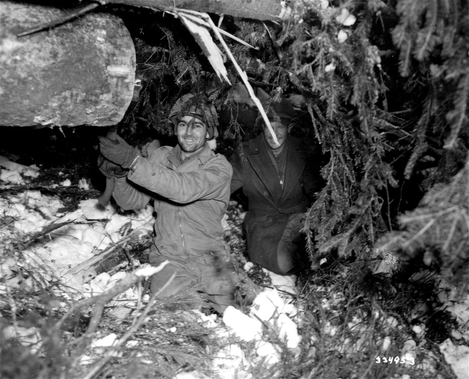 SC 334953 - Pfc. Pete Malenovich, Burgetstown, Pa., and Pfc. Oscar Haddock, Tulsa, Okla., both of the 38th Infantry, pause while digging a bazooka position on the front in the Krinkelter woods, Germany.