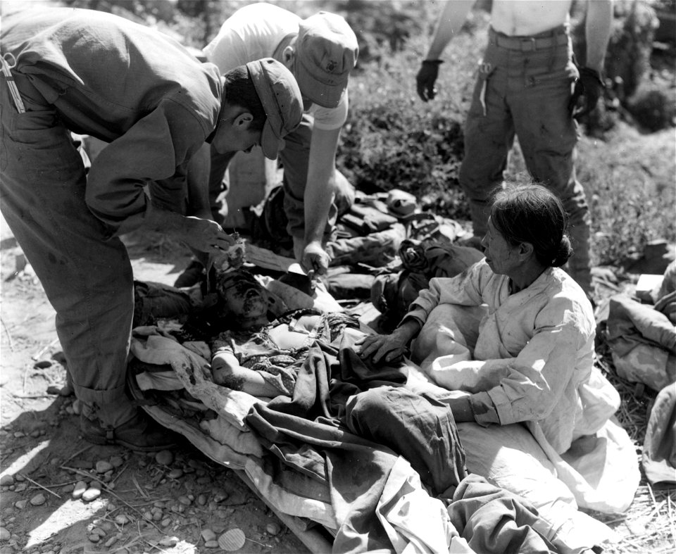 SC 349053 - Navy corpsmen assigned to the 5th Mar. Regt. attend a Korean girl who was injured during the fighting at the Han River. 20 September, 1950.