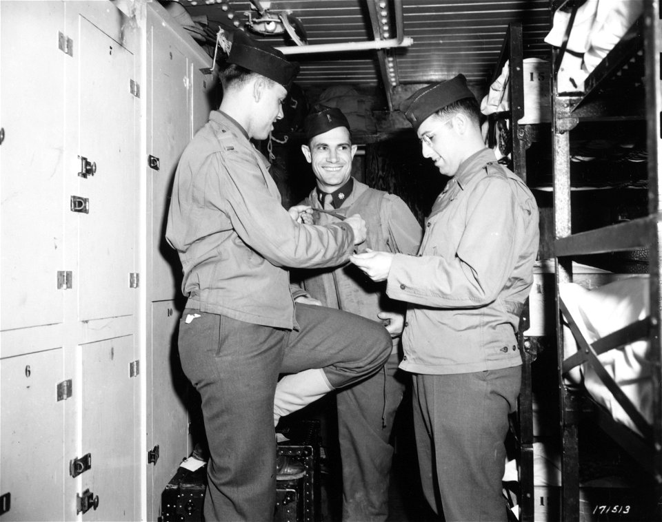 SC 171513 - 2nd Lt. R.C. Goodfellow (left), Cincinnati, Ohio, 1st Lt. William Davidson, Montgomery, Ala., and 1st Lt. Robert Schmidt, Baltimore, Md., explore the fit of a life jacket...