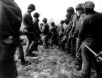 SC 337257 - Men hauling guns up the slopes of Lily Beach. Kiska. 16 August, 1943.