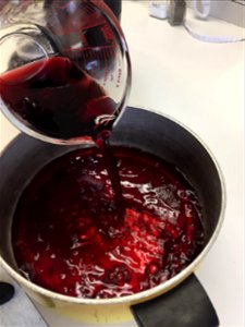 Adding grape juice to cooking pan photo