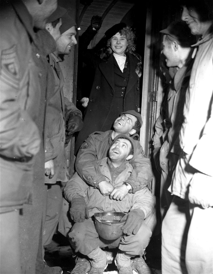 SC 405004 - American soldiers in France joke with 21 year-old Sonya Kalinina, a Russian war refugee and one of the many liberated by U.S. forces from German slave labor.