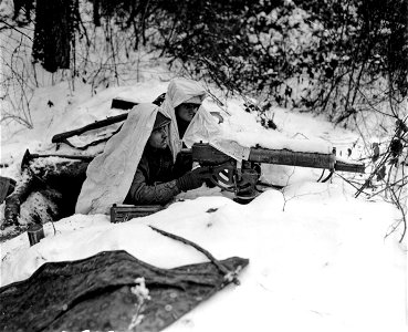 SC 365324 - Two infantrymen of the 142nd Infantry Regiment, 36th Infantry Division, Seventh U.S. Army wear white capes to camouflage them in the snow surrounding their dugout in woods of Bischwiller Area. photo