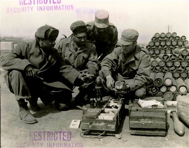 SC 364047 - (L-R) Cpl. Willie Nears, Pasadena, Calif., Sgt. Jeorge T. Hilyard, San Pedro, Calif., and Sgt. George Pettis, Philadelphia, Pa., members of 630th Ord. Ammo Co., examine captured Chinese ammo at Seoul.