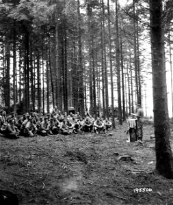 SC 195506 - Using gas cans for an altar, Chaplain James S. Hannaford, Slater, Mo., conducts open-air Protestant services near Konzen, Germany. 17 October, 1944. photo