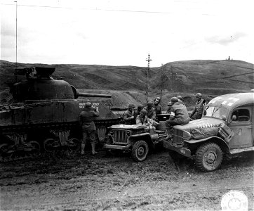 SC 196292 - Tankers, signalmen and medics gather around a radio jeep to get the latest election returns. 7 November, 1944. photo