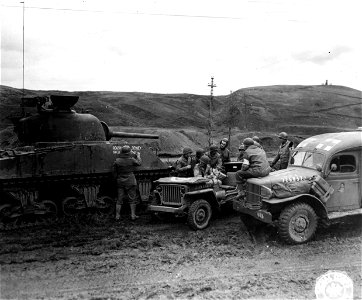 SC 196292 - Tankers, signalmen and medics gather around a radio jeep to get the latest election returns. 7 November, 1944.