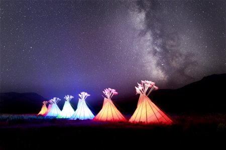 Yellowstone Revealed: illuminated teepees and Milky Way at North Entrance in Gardiner, Montana photo