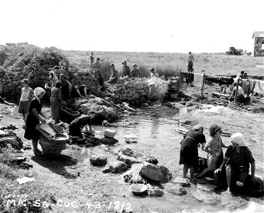 SC 180059 - Italian women open up and outdoor laundry under the ancient ruins of Paestum, Italy.