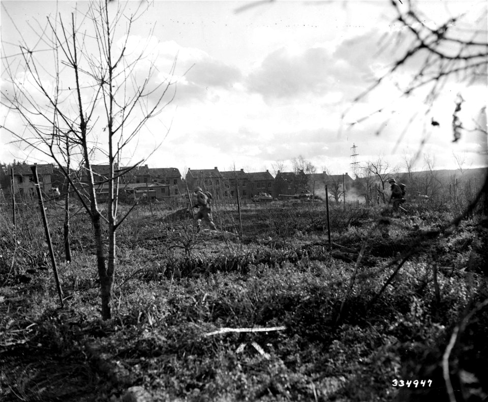 SC 334947 - Tank-supported American infantrymen push through the outskirts of the newly captured town and continue advance on objective beyond the German city of Weisweiler. 25 November, 1944.