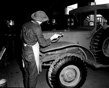 SC 184888 - A German prisoner of war at Camp Wallace, Texas, is shown at work in the Service Command Shop #5 spraying paint on a truck that has been repaired. 1943.