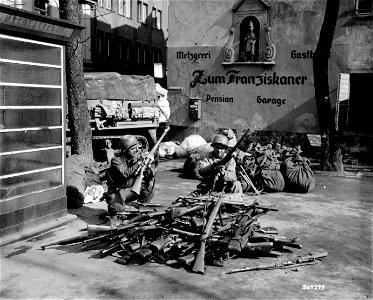 SC 364293 - T/5 Russell W. McCarthy, Mancelona, Mich., left, and T/5 Stanley W. Stochla, Detroit, Mich., examine captured German guns taken by the 11th Armored Division, Third U.S. Army. photo