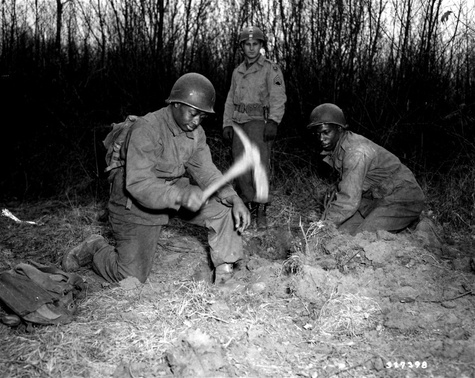 SC 337398 - Pvt. Felix Lawson, 534 West St., [illegible], Md., and Pvt. Sammie Jenkins, 1200 17th St. Tuscaloosa, Ala., demonstrate the proper method of digging a foxhole.