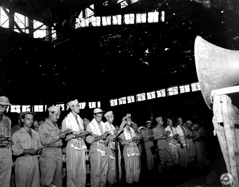 SC 211450 - GIs in front of the stadium are wearing Jewish holy shawls with prayer books in hand while services are going on at Rizal Stadium, Manila. 7 September, 1945.