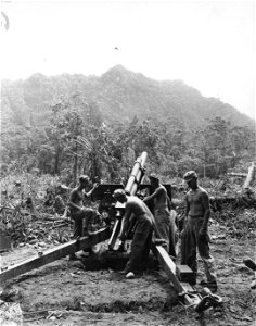 SC 364575 - Crew of No. 1 gun load piece (105mm howitzer) to fire on enemy positions beyond the ridge in the distance.