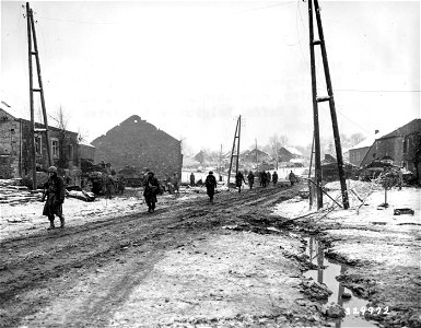 SC 329972 - Infantrymen of the 290th Regiment, 75th Division, move through the shell-torn town of Beffe, Belgium, on the drive toward La Roche. 5 January, 1945. photo