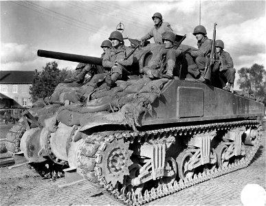 SC 195693 - GIs of the 3rd Armored Division sitting on top of a Sherman tank near Stolberg, Germany, are: