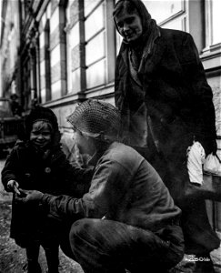 SC 405016 - Pfc. Alfred George, Brooklyn, N.Y., makes friends with little Ukrainian girl by offering her candy in Duren.