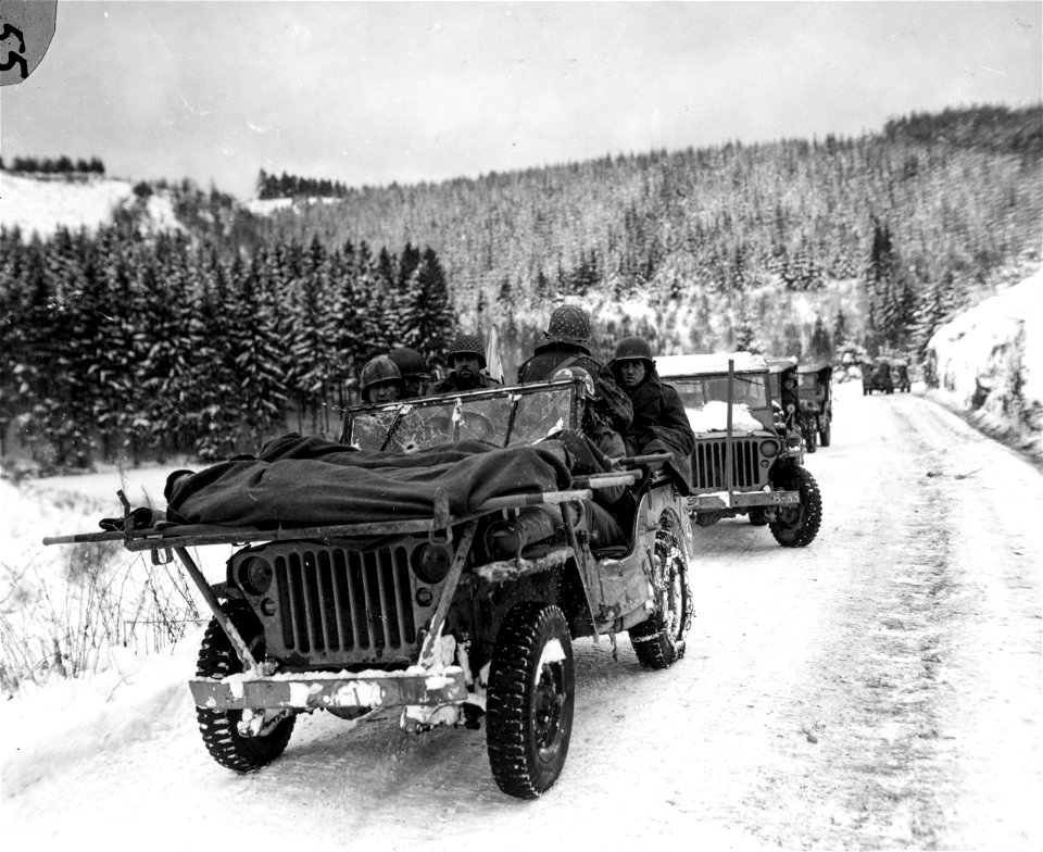 SC 199079 - Medics of the 84th Division are shown evacuating wounded soldiers in a jeep ambulance.