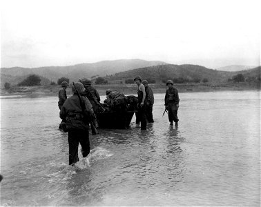 SC 348674 - Men of the 21st Inf. Regt., 24th Inf. Div. load soldiers, wounded while crossing the Naktong River, in Korea, into a shallow boat, to be pulled ashore, where medical aid can be given. 19 September, 1950. photo