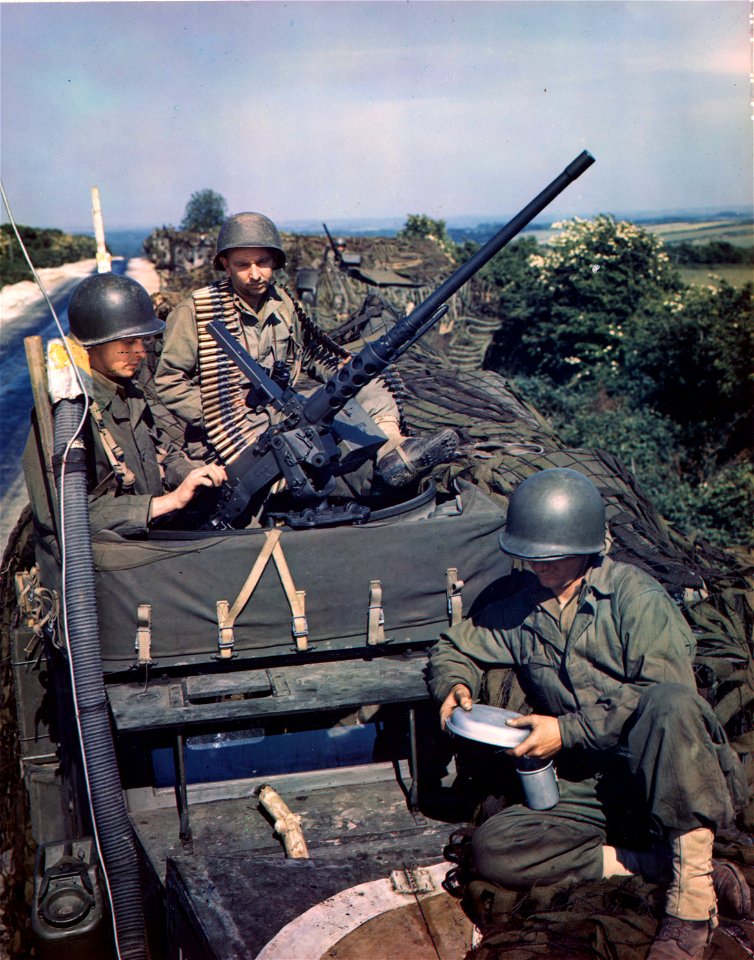 C-1081 - Three soldiers on top of a halftrack make last minute check on their guns and equipment prior to boarding a ship for the invasion.