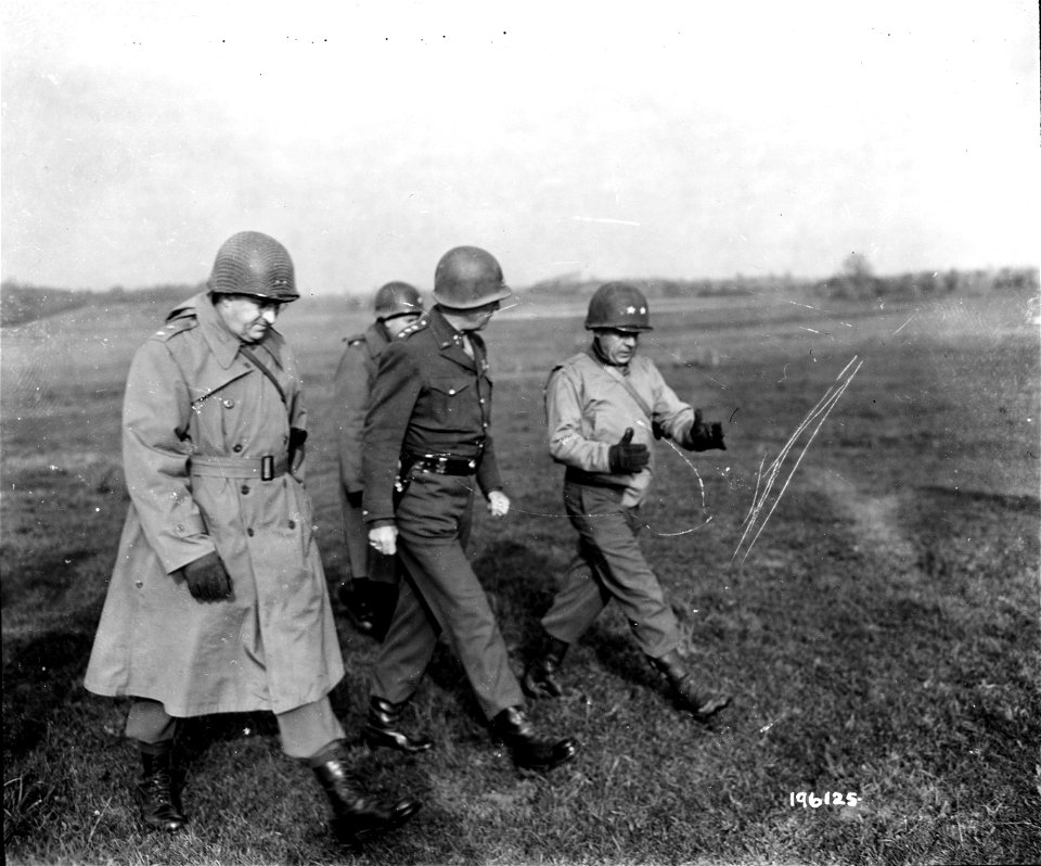 SC 196125 - Lt. Gen. George S. Patton, Jr., and Maj. Gen. W. S. Paul discuss tactics of war while walking in field near headquarters of Maj. Gen. Paul in France. 3 November, 1944.