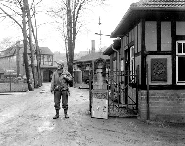 SC 335408 - Pfc. Arthur Wippman, Chicago, Ill., stands guard at gate of captured small arms factory in Suhl, Germany.