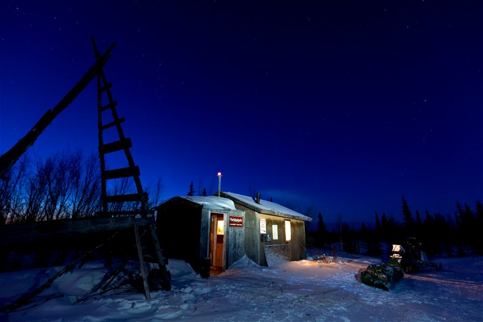 A snowmachine and sled outside the Paniqsigvik shelter cabin.