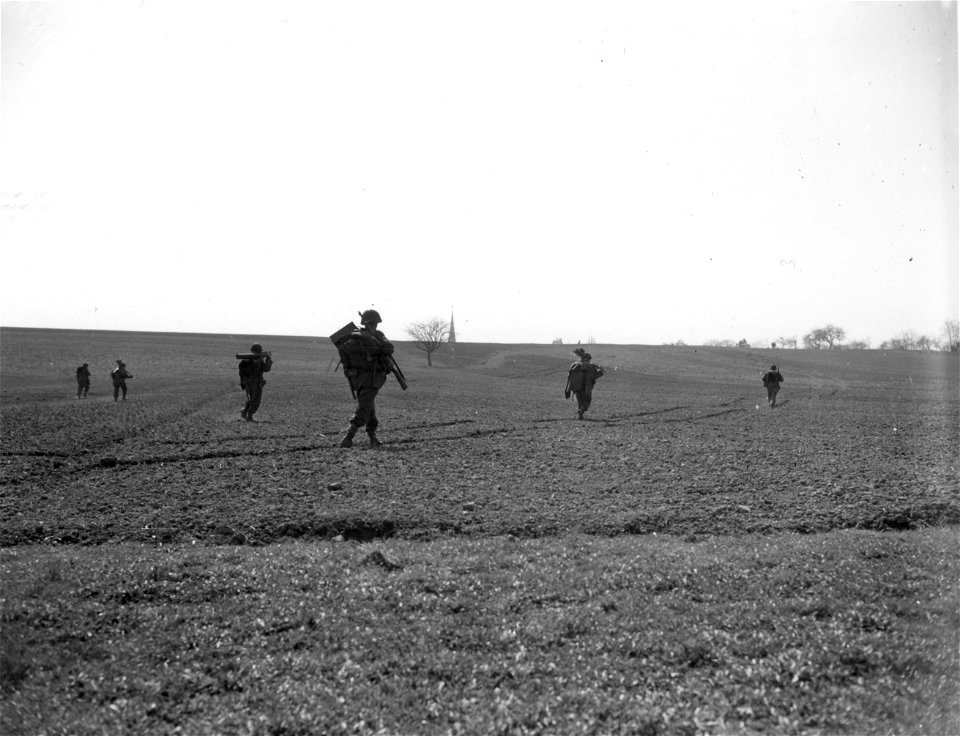 SC 270641 - 7th U.S. Army infantrymen carrying machine guns and other weapons advance on Wetzhausen, Germany. 9 April, 1945.