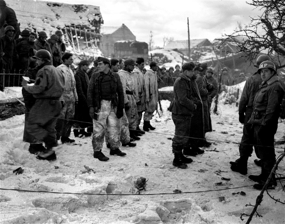 SC 199105 - German prisoners taken in the Ardennes sector by 3rd Armored Division are checked before being moved to cages.