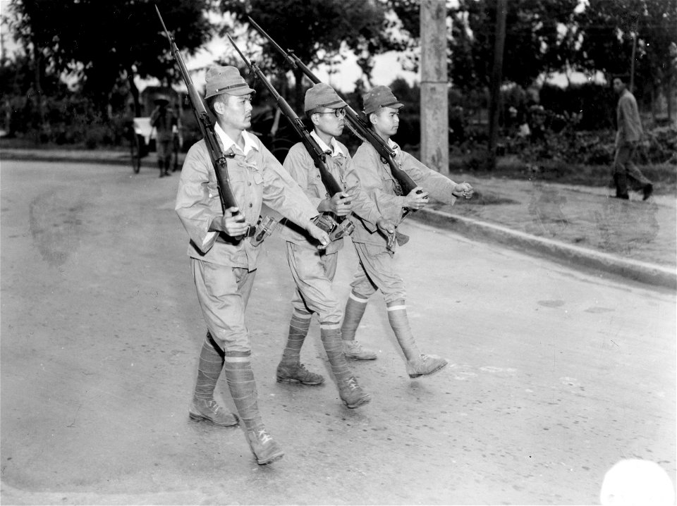 SC 221534 - Medum shot of 3 Jap soldiers marching through the residential section of Nanking, China.