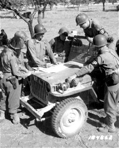 SC 184862 - 1st Division Military Police, near front lines on Sicily, get map directions from from Major Thomas Lanser, New York, 1st Division Provost Marshal, before going up to their posts at the frontline. 19 July, 1943.