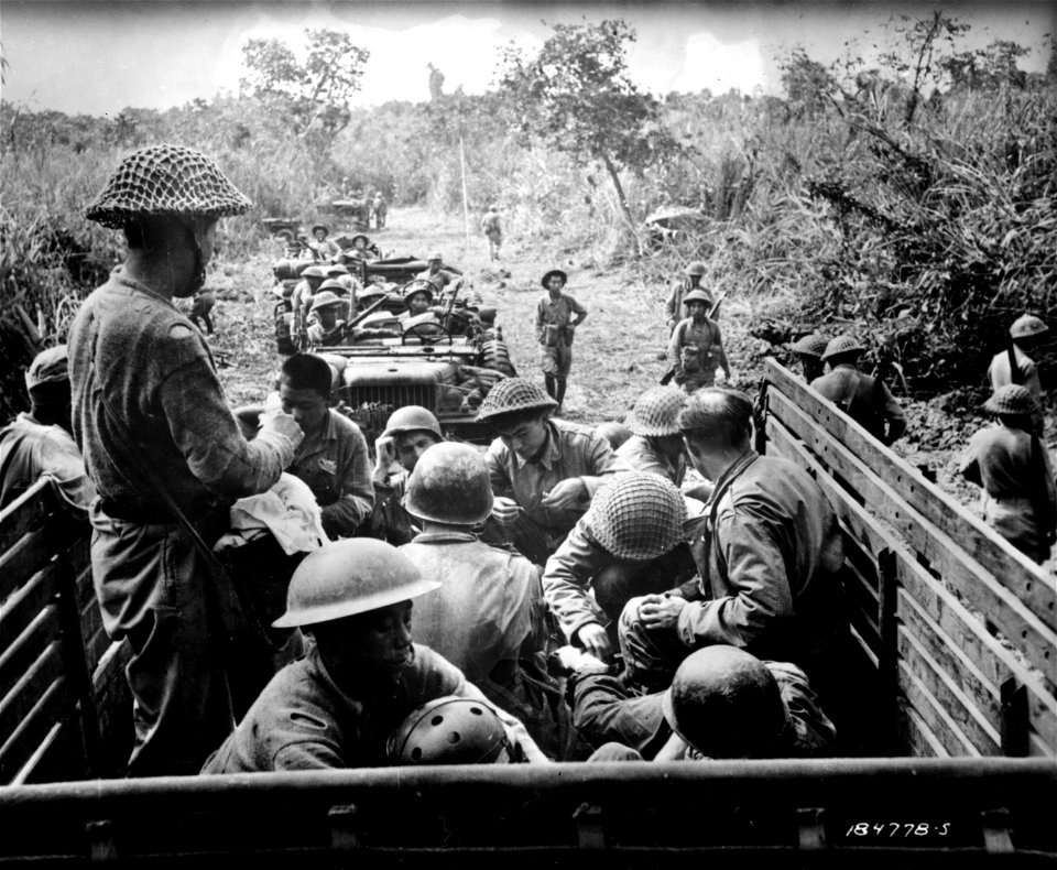 SC 184778-S - Chinese and American troops who have just received first aid treatment are seen in a 2½ ton truck for transfer to the far rear where they will receive hospital care.
