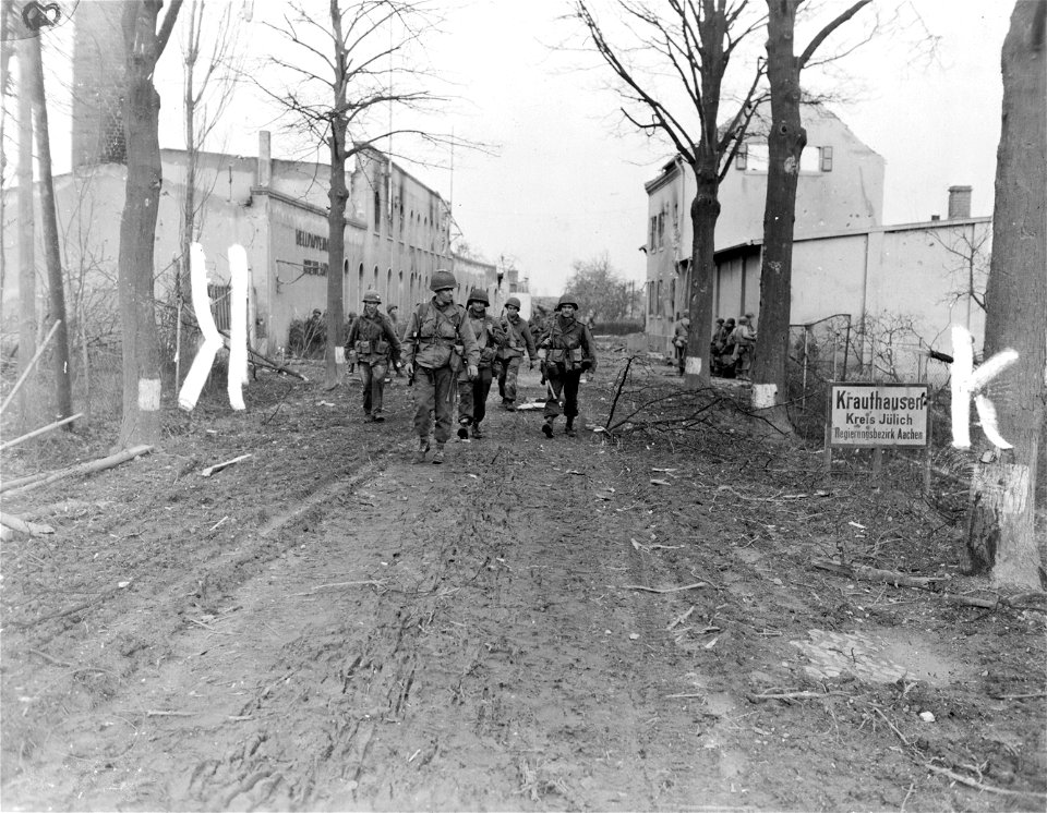 SC 334965 - Infantrymen of the 30th Division, 9th U.S. Army, patrol street in Krauthausen, Germany, following capture of town after surprise crossing of Roer River on morning of Feb. 23.