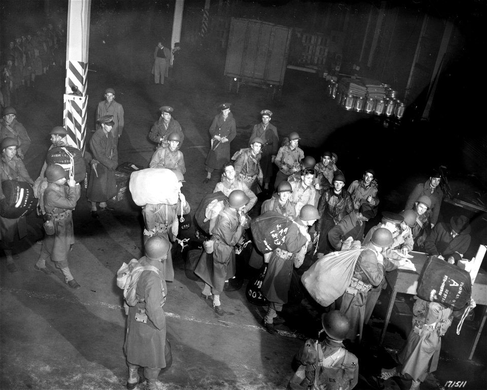 SC 171511 - A Company passes before the checking desk as it prepares to go up the gangplank for overseas. 22 January, 1943.