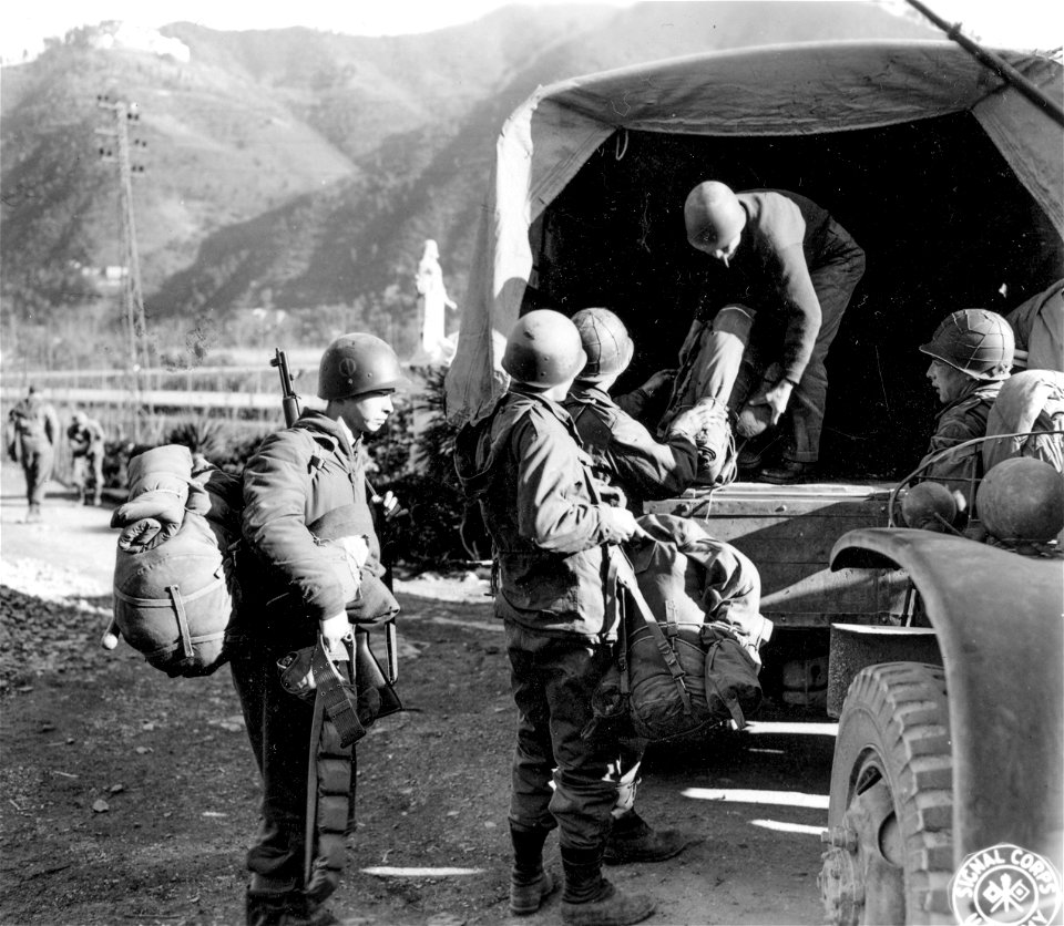 SC 329818 - Packs are loaded onto trucks by men of Co. "C", 1st Bn., 337th Regt., in preparation for the movement of their C.P. to another area. 6 January, 1945.