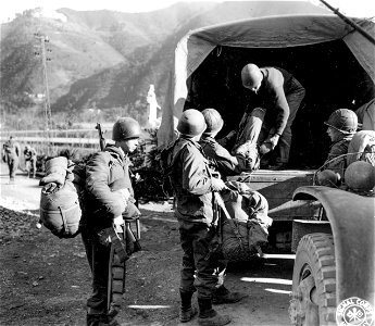SC 329818 - Packs are loaded onto trucks by men of Co. "C", 1st Bn., 337th Regt., in preparation for the movement of their C.P. to another area. 6 January, 1945. photo
