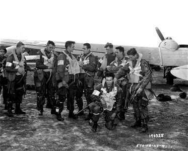 SC 196325 - American Airborne forces check each other's gear before loading into aircraft which will carry them into Holland for still another invasion of what was once Hitler's fortress Europe.