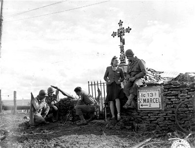 SC 195641 - L-R: Pfc. Edward J. Motyl, Scitico, Conn.; Pfc. Joseph Bukea, Merdon, Conn., and Cpl. Tony Marinaro, Waterbury, Conn., warm themselves at a fire near a wayside shrine...