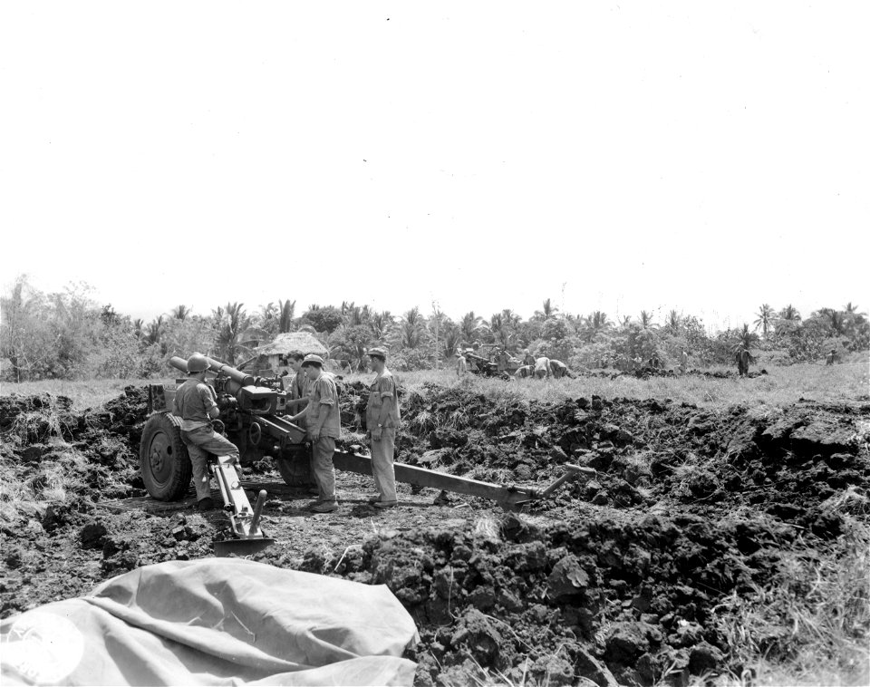 SC 364524 - Men of Btry "C", 147th F.A., dig in 105mm howitzer in field near Pili, Luzon.