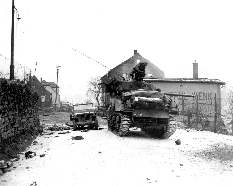 SC 337279 - M4 tank stands guard to cover infantrymen in town of Wingen, France, after Yanks took it from Germans who counterattacked during during night. Destroyed jeep stands behind tank. 7 January, 1945.