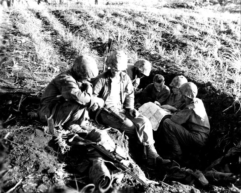 Major Thomas Gaines, of New Braunsfels, Texas in frontline foxhole with officers of his engineering unit. Saipan. June, 1944.