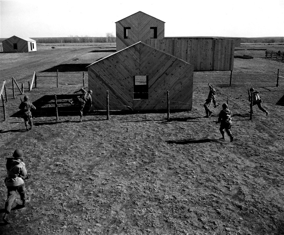 SC 364247 - A squad from Company B, 83rd Engrs., Fort Sill, Okla., closes in on a house at the newly-opened Combat Village. 17 January, 1951.