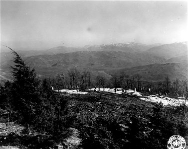 SC 374814 - A white-clad combat patrol of the 85th Mtn. Regt., 10th Mtn. Div., cross snow patched ground near the crest of strategic Mt. Belvedere.